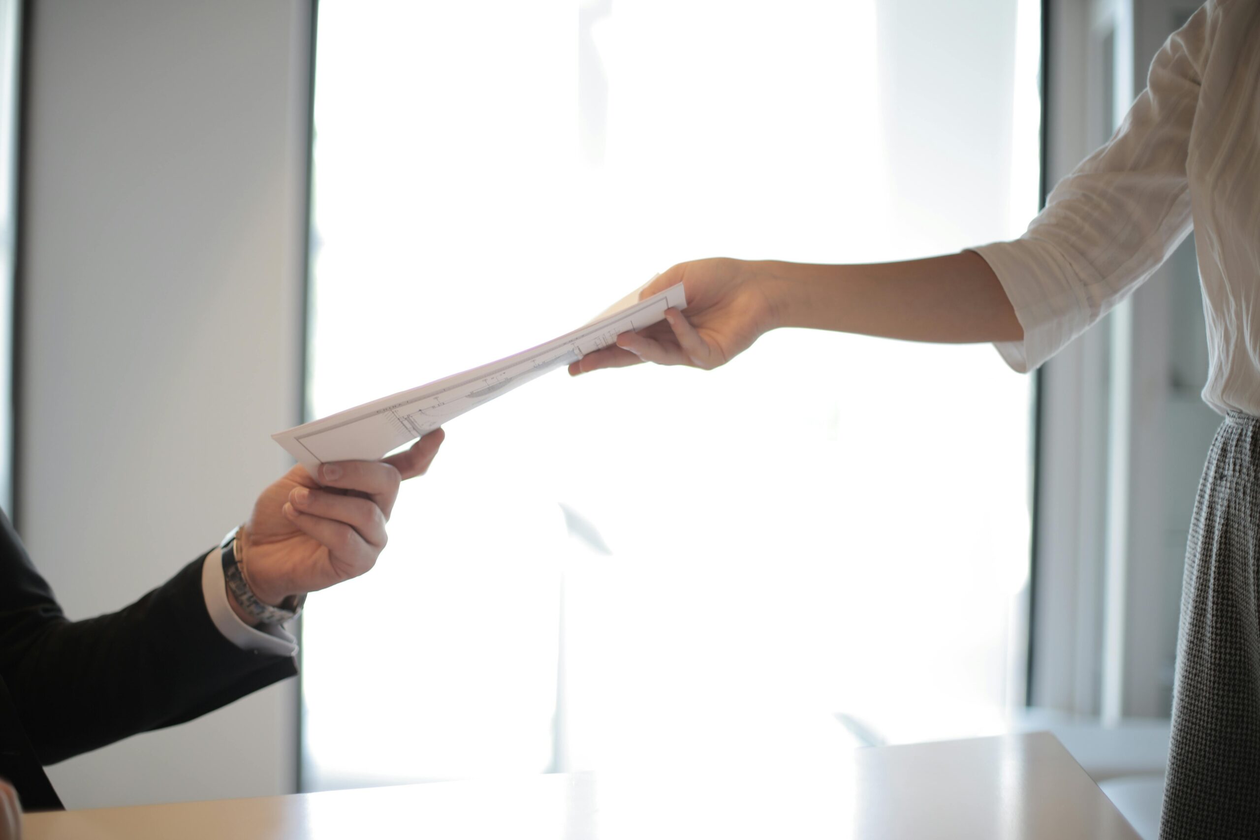 Persons handling paper document.