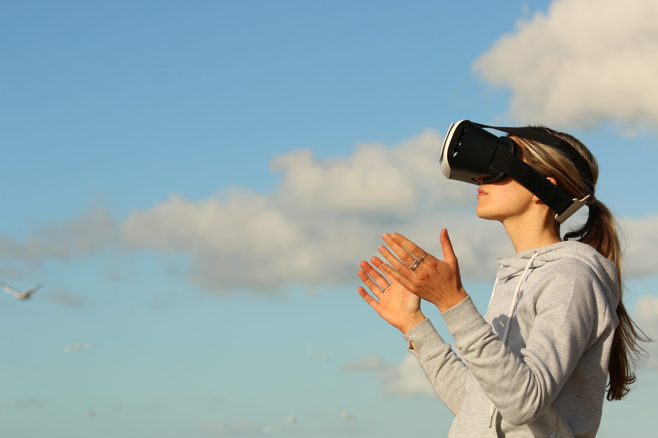 Woman using VR googles outdoors.